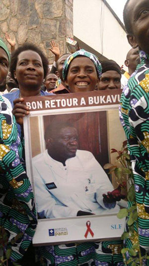 women hold sign welcoming Dr. Mukwege