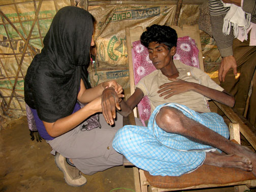 Doctor examines a Burmese refugee in a makeshift camp