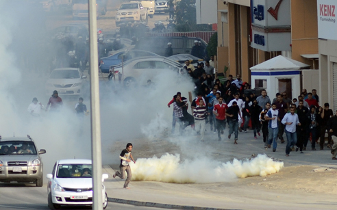 Protestors in Bahrain take cover from tear gas, December 2011